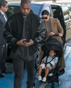 Au revoir, Paris! Kim Kardashian rejects spring style in favour of a heavy coat as she finally heads home with North and Kanye West after three-country tour