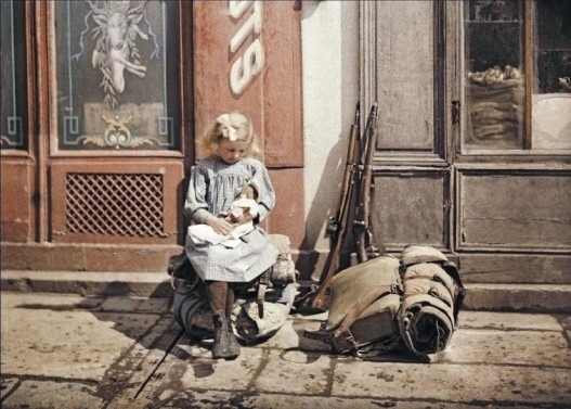 Девочка держит свою куклу сидя рядом с солдатскими вещами, Реймс, Франция, 1917 год