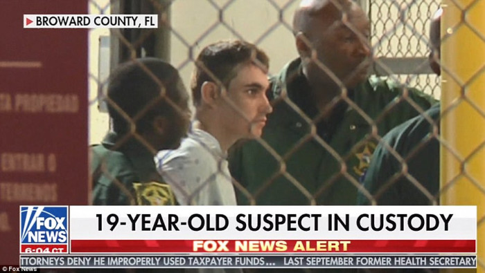 Public defender puts arm around shackled and cowering Florida gunman at his first court appearance: 'White supremacist' is silent as he is ordered to be held without bond for killing 17 people