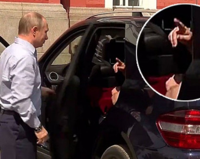 Russian leader Vladimir Putin opens car door for mysterious lady in red