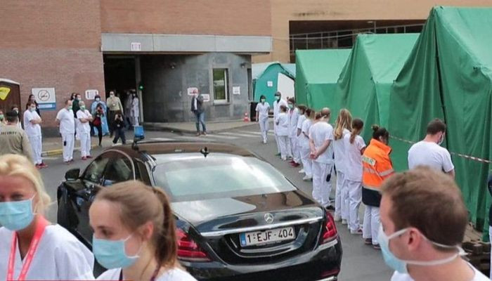 Coronavirus: medics turn backs on Belgium's prime minister in silent protest