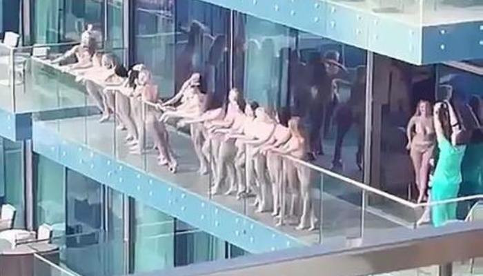 More than a dozen naked girls posed naked on the balcony of a skyscraper