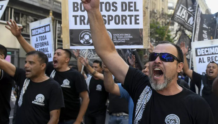 Argentina’s president announces economy deregulation as thousands protest against austerity