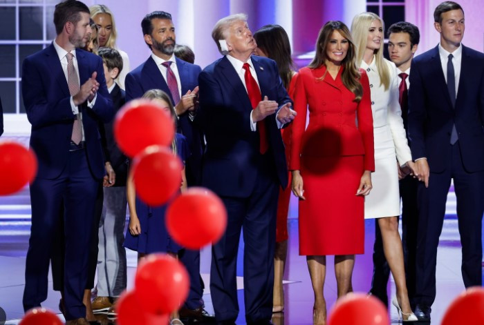 Melania Trump stuns in red as she walks into the Republican convention to a roaring crowd to watch husband Donald speak